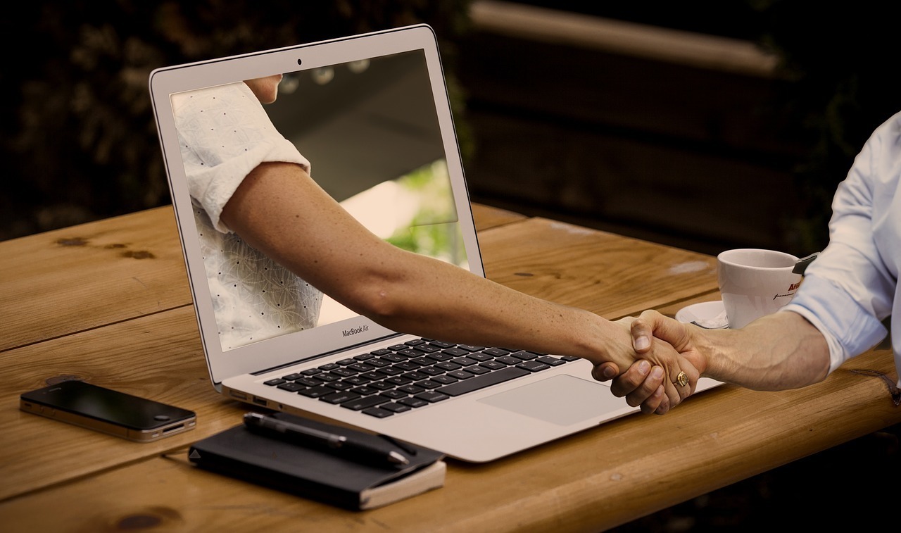 handshake through laptop screen